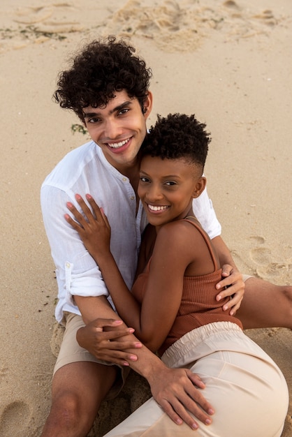 Foto pareja amorosa mostrando afecto en la playa cerca del océano