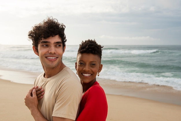 Foto pareja amorosa mostrando afecto en la playa cerca del océano