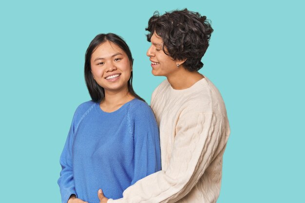 Una pareja amorosa y multirracial se abraza en el estudio.