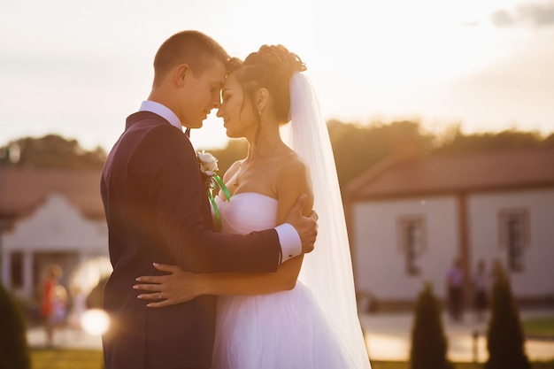 Foto una pareja amorosa con los ojos cerrados se abraza tiernamente al atardecer en los rayos