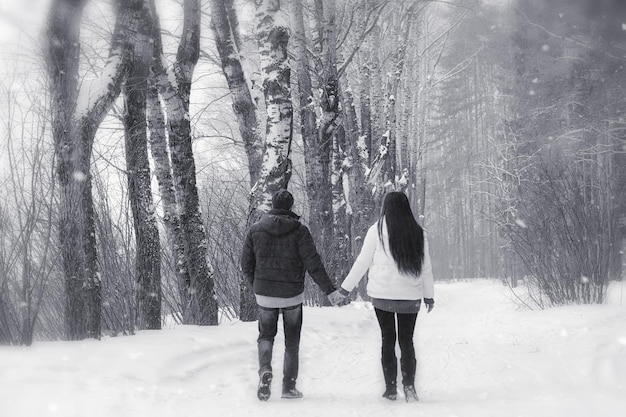 Una pareja amorosa en un paseo invernal. Hombre y mujer en una cita en el parque en invierno. Amigos en un parque de invierno