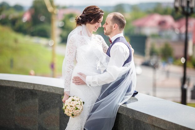 Una pareja amorosa de recién casados camina por la ciudad vieja en un día soleado de verano