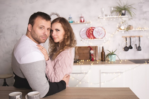 Pareja amorosa en ropa de invierno en la cocina