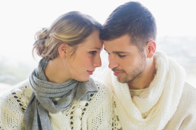 Pareja amorosa en ropa de invierno sobre fondo brillante