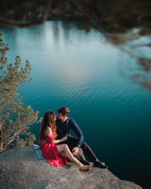 Foto una pareja amorosa se sienta al borde de un acantilado