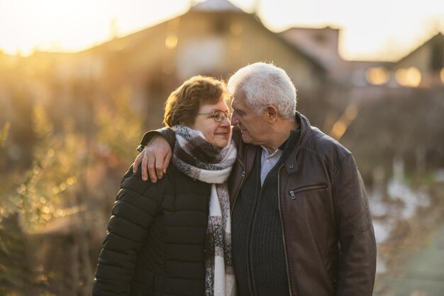 Una pareja de ancianos abrazándose al atardecer