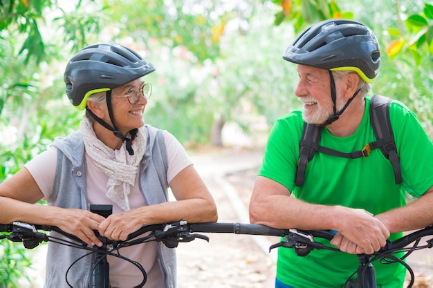 Foto una pareja de ancianos abrazándose en el parque de primavera al aire libre divirtiéndose y disfrutando juntos mirando los árboles dos personas viejas y maduras enamoradas que se cuidan unas a otras