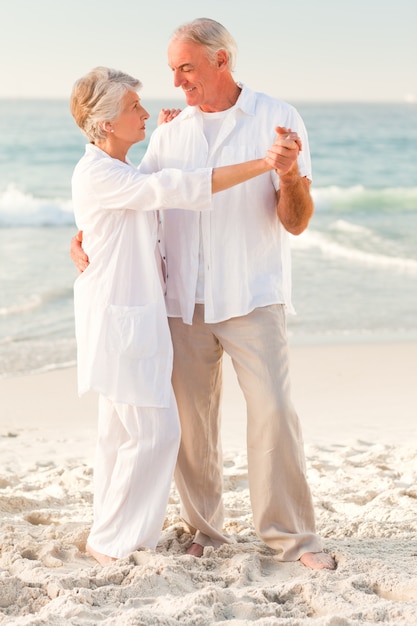 Pareja de ancianos bailando en la playa