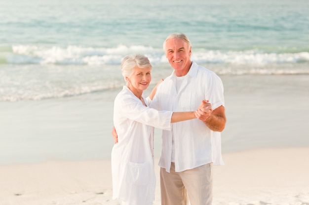 Pareja de ancianos bailando en la playa