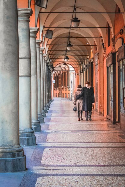 Pareja de ancianos en una calle vacía de Bolonia Italia