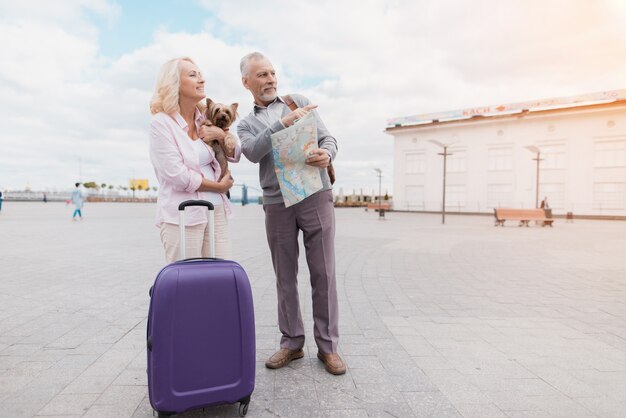 Pareja de ancianos camina a lo largo del terraplén con su perrito.