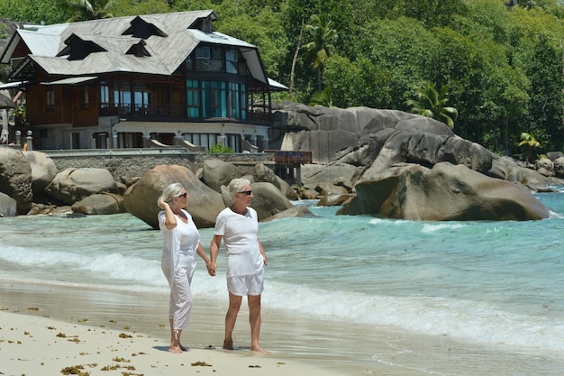 pareja de ancianos descansa en playa tropical