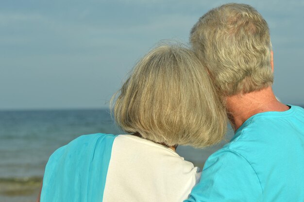 pareja de ancianos descansa en playa tropical