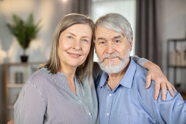 Pareja de ancianos devotos de pie juntos y posando en la cámara