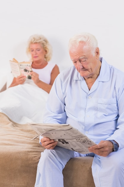 Pareja de ancianos leyendo en la cama