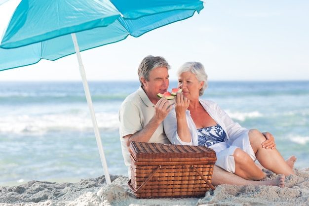 Pareja de ancianos picniking en la playa