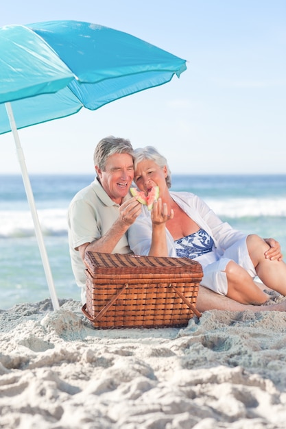 Pareja de ancianos picniking en la playa