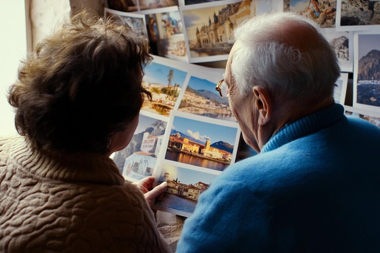 Una pareja de ancianos recordando mientras miran fotos de viaje en un ambiente interior acogedor IA generativa