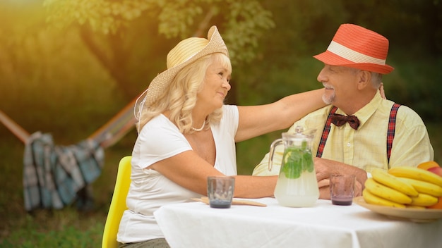 Pareja de ancianos sentados en el jardín