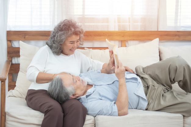 pareja de ancianos sentados en el sofá leer libros en casa