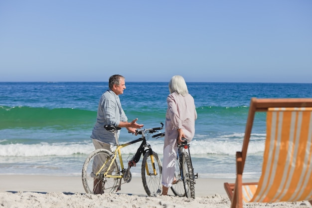 Pareja de ancianos con sus bicicletas en la playa