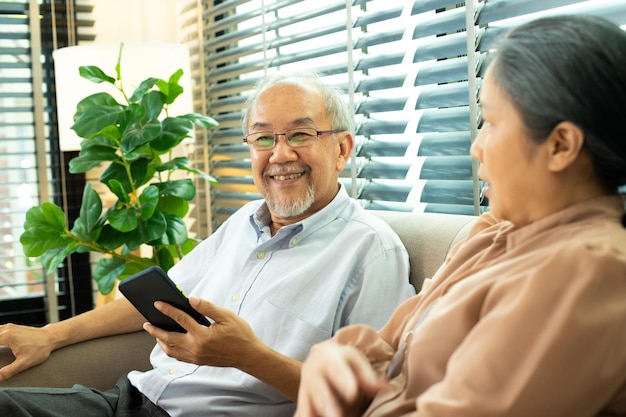 La pareja de ancianos tiene una conversación juntos después de la jubilación El esposo, la esposa, la persona tiene una pensión para un momento romántico con una sonrisa feliz, disfrute de las redes sociales de Internet en el espacio digital de copia de teléfonos inteligentes