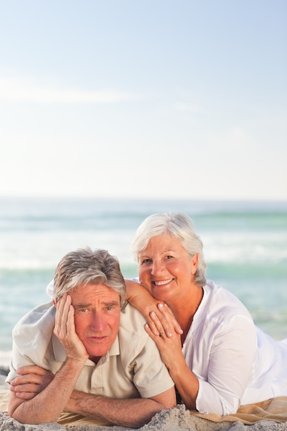 Pareja de ancianos tumbado en la playa