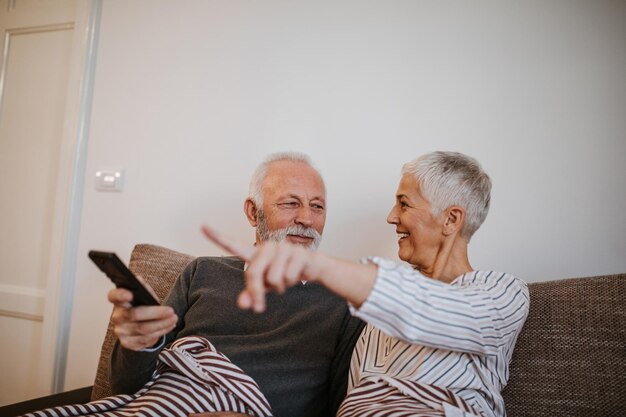 Pareja de ancianos viendo la televisión en casa