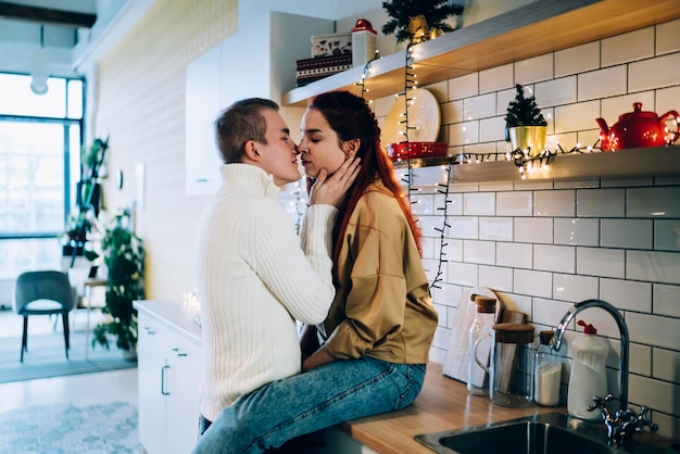 Pareja apasionada preparándose para un tierno beso en Navidad