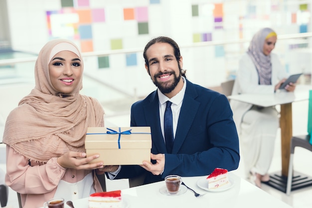 Pareja árabe con tazas de té y pastel