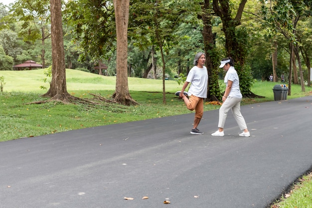 Pareja asiática activa senior en ropa deportiva para correr en el parque.