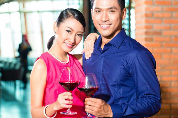 Pareja asiática con copa de vino tinto