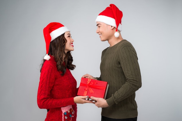 Pareja asiática dándose regalos de Navidad