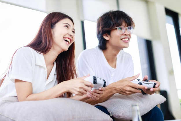 Pareja asiática jugando un videojuego juntos en casa Personas actividades de ocio