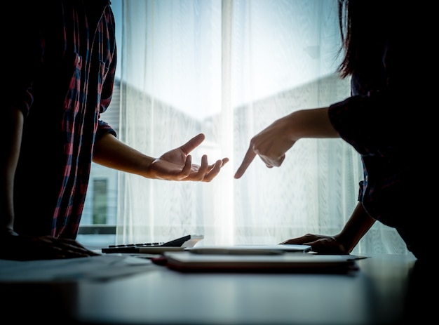 La pareja asiática de la silueta está luchando por las ventanas