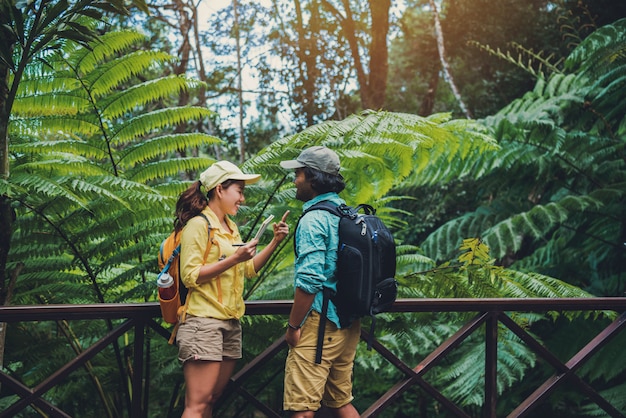 Pareja asiática viajes naturaleza caminando relajarse y estudiar la naturaleza en las fores.