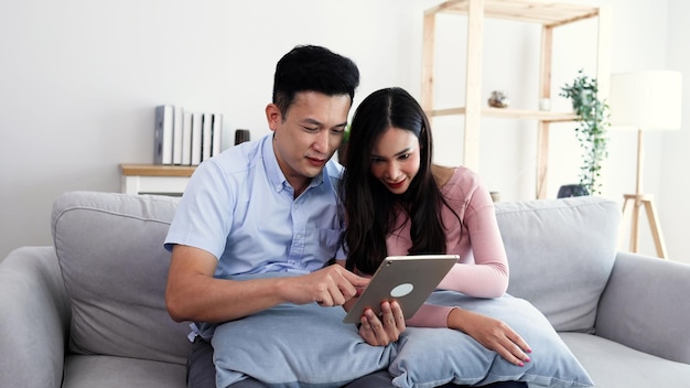 Foto pareja asiática viendo películas en línea en tableta