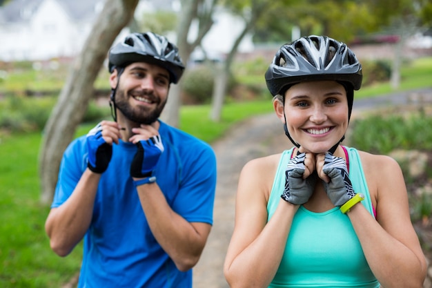 Foto pareja atlética con casco de bicicleta