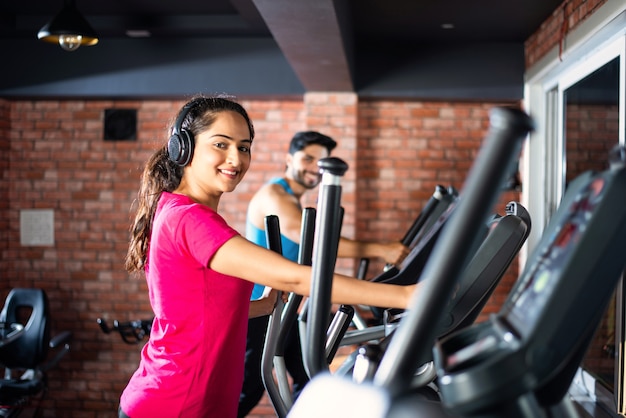Pareja atractiva asiática india haciendo programa de entrenamiento cardiovascular en el gimnasio o gimnasio, focys selectivos - concepto de salud y fitness