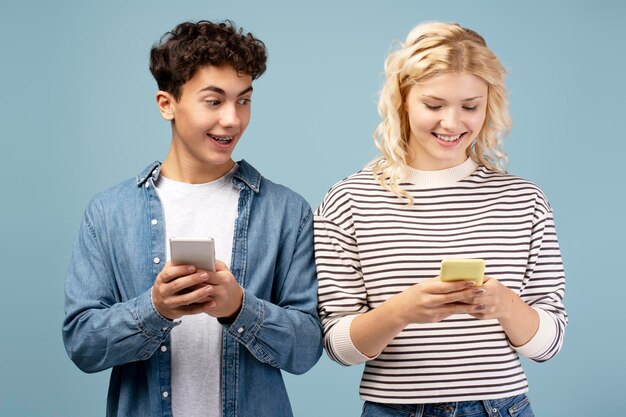 Pareja atractiva y positiva novio y novia usando mensajes de texto de teléfono inteligente juntos