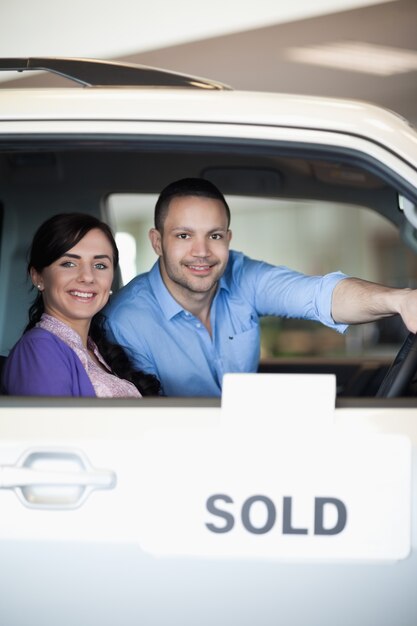 Foto pareja en un auto vendido