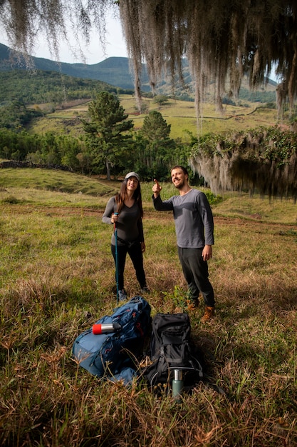 Pareja aventurera de tiro completo vivaqueando