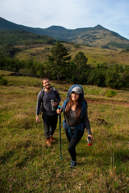 Pareja aventurera de tiro completo vivaqueando