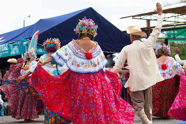 Pareja bailando en falda colorida y sombrero de paja