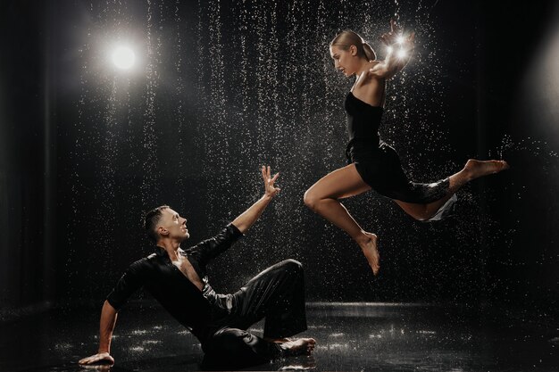 Foto una pareja de bailarines en un fondo negro en un estudio en la zona acuática