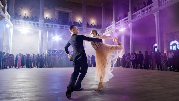 Una pareja de bailarines interpreta un vals en un gran escenario profesional