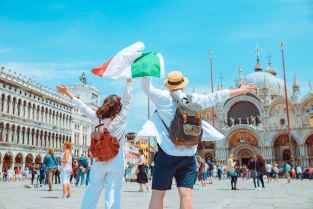 Pareja con bandera italiana venecia plaza central san marco copia espacio