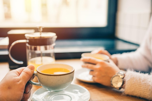 Una pareja bebe té de naranja en un café juntos por la noche