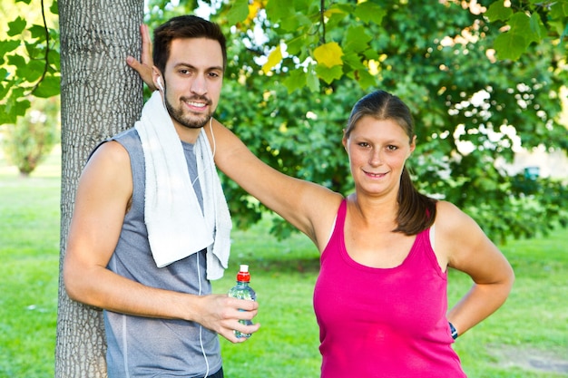 Una pareja bebiendo agua después del deporte.