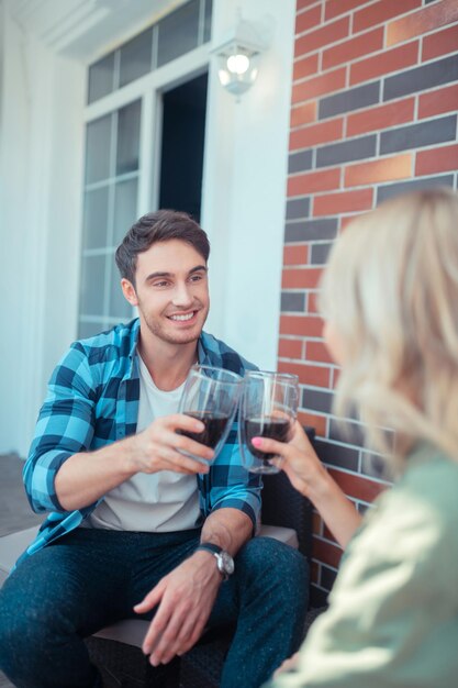 Pareja bebiendo café mientras disfruta del buen tiempo sentado en el balcón al aire libre